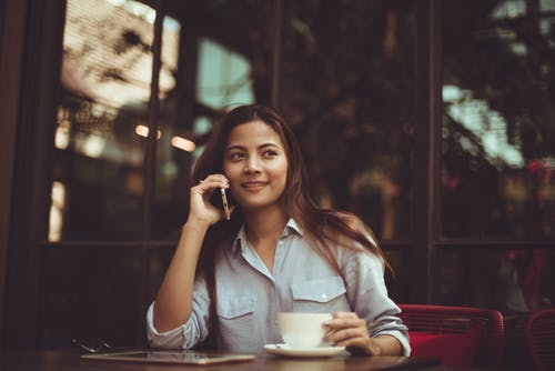 woman-on-the-phone-at-table-with-coffee