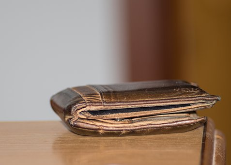 leather wallet sitting on the corner of a wooden table
